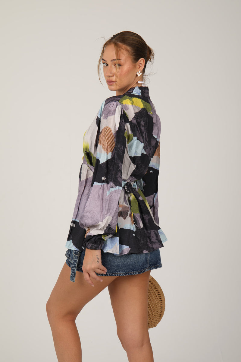 This striped blouse with balloon sleeves and a front tie design adds a fun and trendy vibe to your outfit