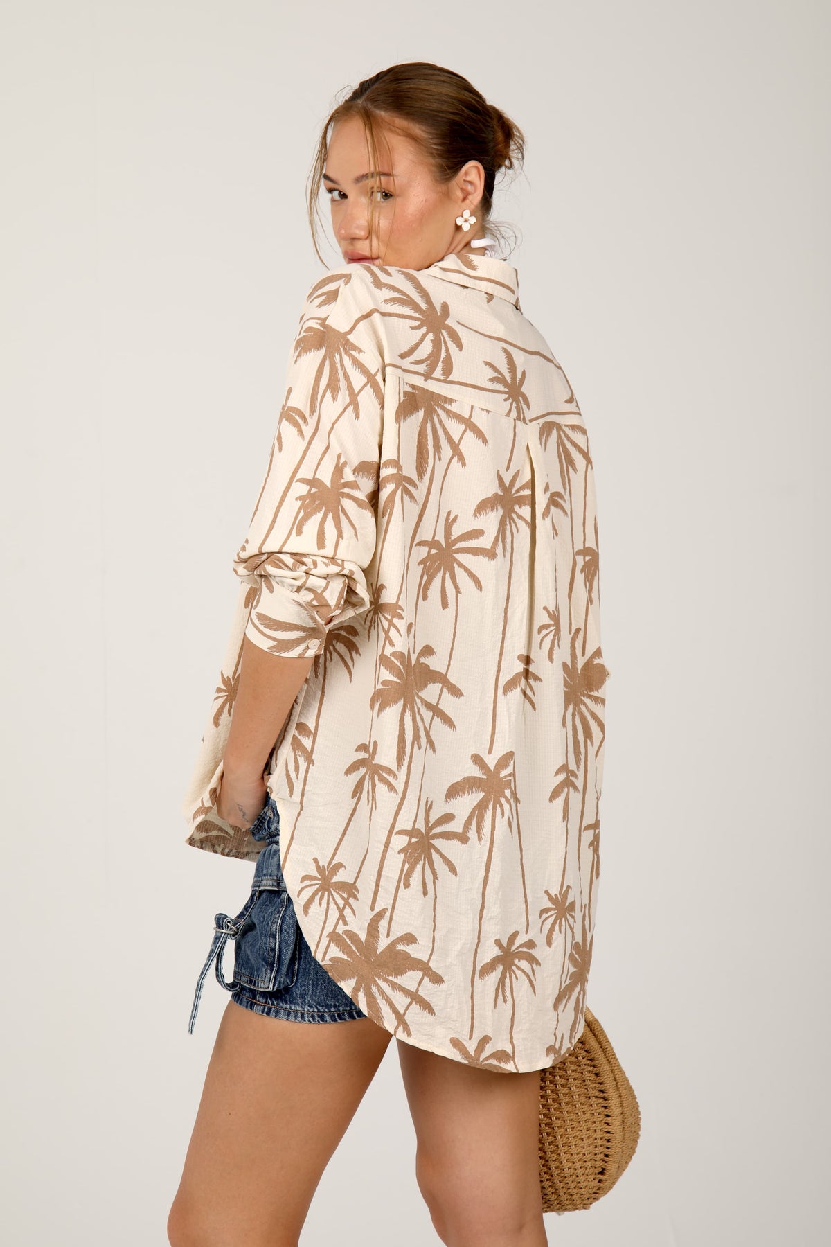 This cream shirt with green palm tree prints offers a relaxed and breezy tropical look, ideal for laid-back summer outings