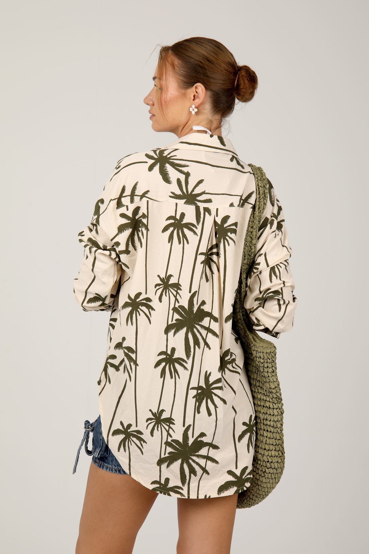 This cream shirt with green palm tree prints offers a relaxed and breezy tropical look, ideal for laid-back summer outings
