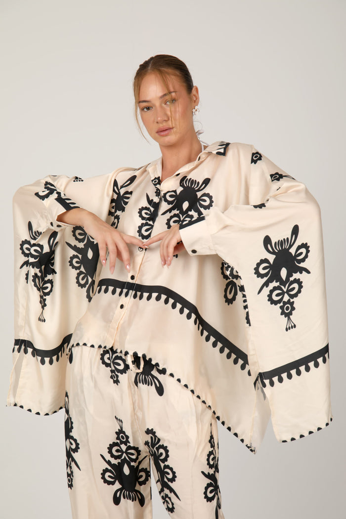 This flowing satin suit, adorned with bold graphic prints, blends comfort and elegance with a chic bohemian flair
