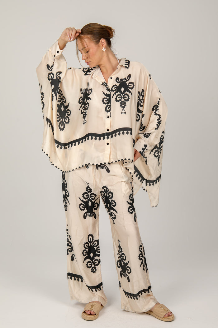 This flowing satin suit, adorned with bold graphic prints, blends comfort and elegance with a chic bohemian flair